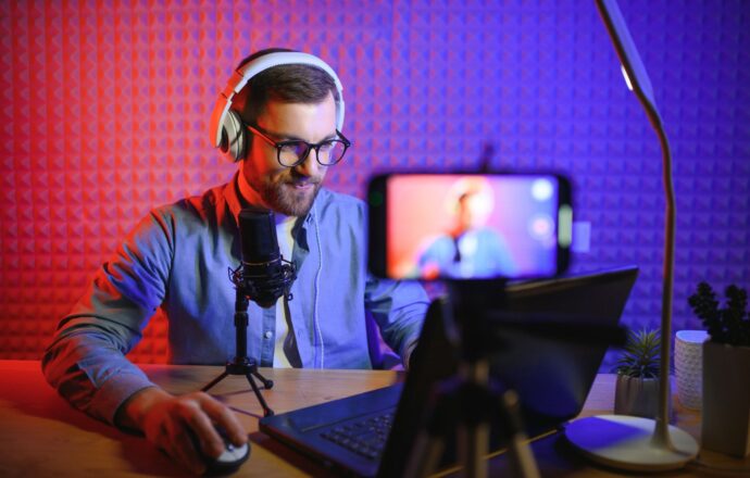 Confident content creator recording with microphone and laptop, OnlyFans manager concept